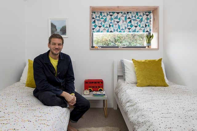 Charlie Luxton sat in a children's bedroom with an Urban Marine Splash Roller blind fitted to the window