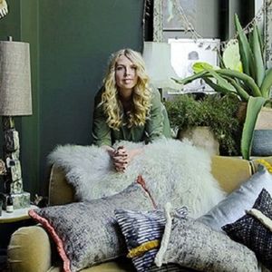 Abigail Ahern leaning over a sofa covered