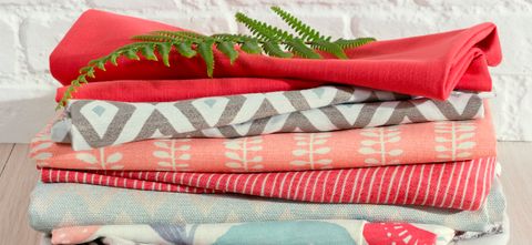 Pile of folded fabrics in pinks, greys and blues from the Natur collection