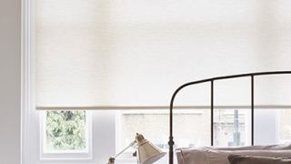 Plain Norfolk Ivory roller blind hung in bedroom