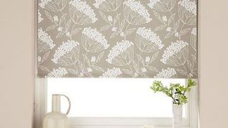 Patterned Elsham Natural roller blinds hung in bedroom