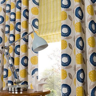 Blue and yellow patterned made to measure curtains combined with a yellow striped roman blind in the living room - Freyja Mustard curtains and Lotta Citron Roman Blinds