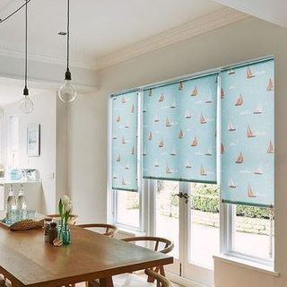 Boats Teal Roller Blinds hung in a dining room