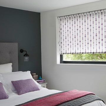 Retta Aubergine roller blind hung in bedroom