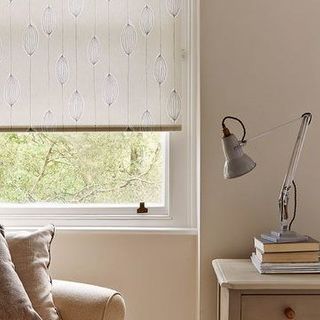 Silas Natural roller blind with seed head design hung in study