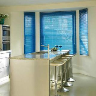 Bright blue Portfolio Sapphire Venetian blinds hanging in a kitchen window