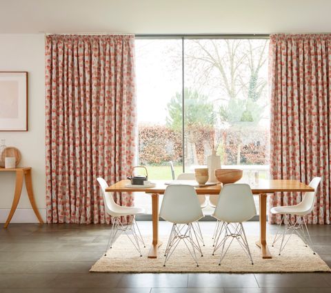 Dining Room with wooden table and large window dressed with Honesty Persimmon Printed Pink Curtains