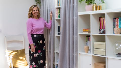 Liz Earle stood in front of a bookshelf with voile curtains fitted to it