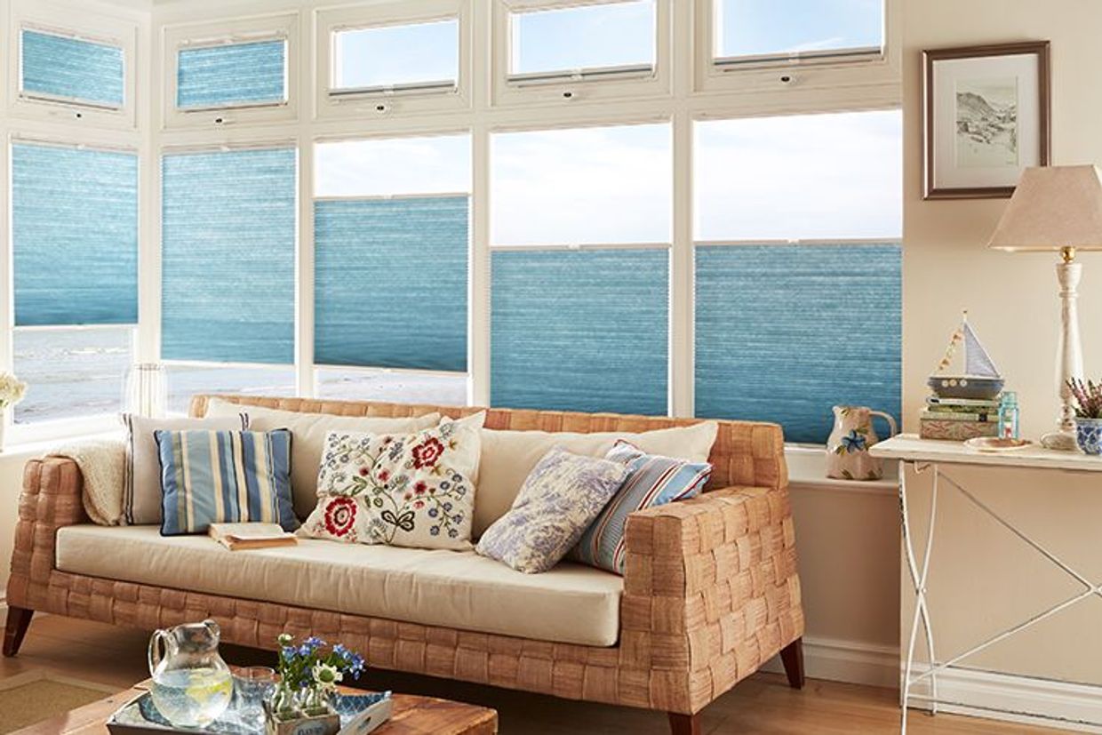 pleated blue blinds in a conservatory living room window