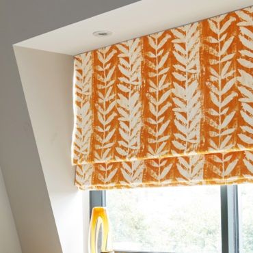 close up of orange patterned roman blind