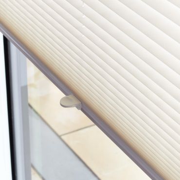 close up of white pleated blinds in a window
