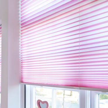 close up of bright pink roller blinds in a window