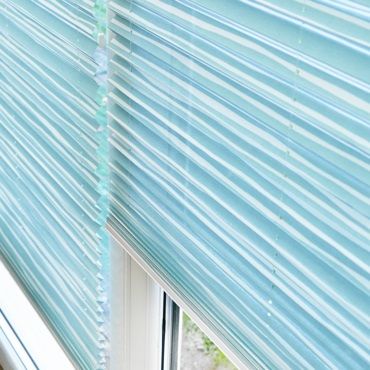close up of blue pleated blinds in a window
