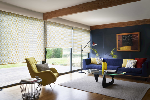 Modern living room with retro style decor and wide windows dressed with retro yellow floral roller blinds