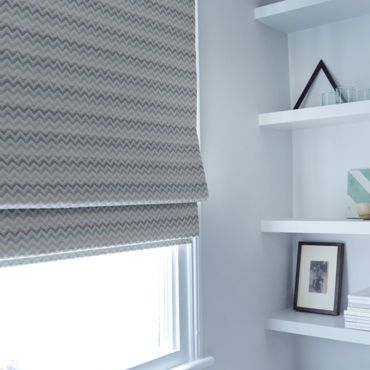 close up of silver roman blind in a window