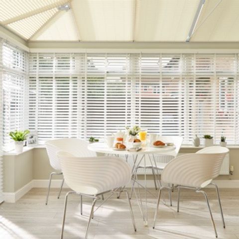 Conservatory with white wooden Venetian blinds and perfect fit roof blinds