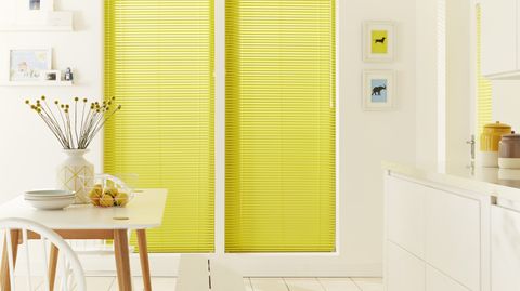 White open plan kitchen diner with contrast yellow venetian blinds