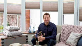 George Clarke sitting in a conservatory fitted with Thermashade TM blinds
