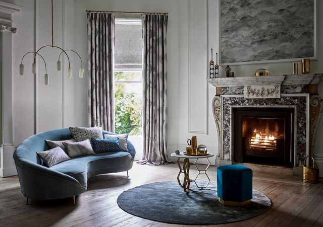 Stately living room with eroded effect curtains over a textured Roman blind at a single window