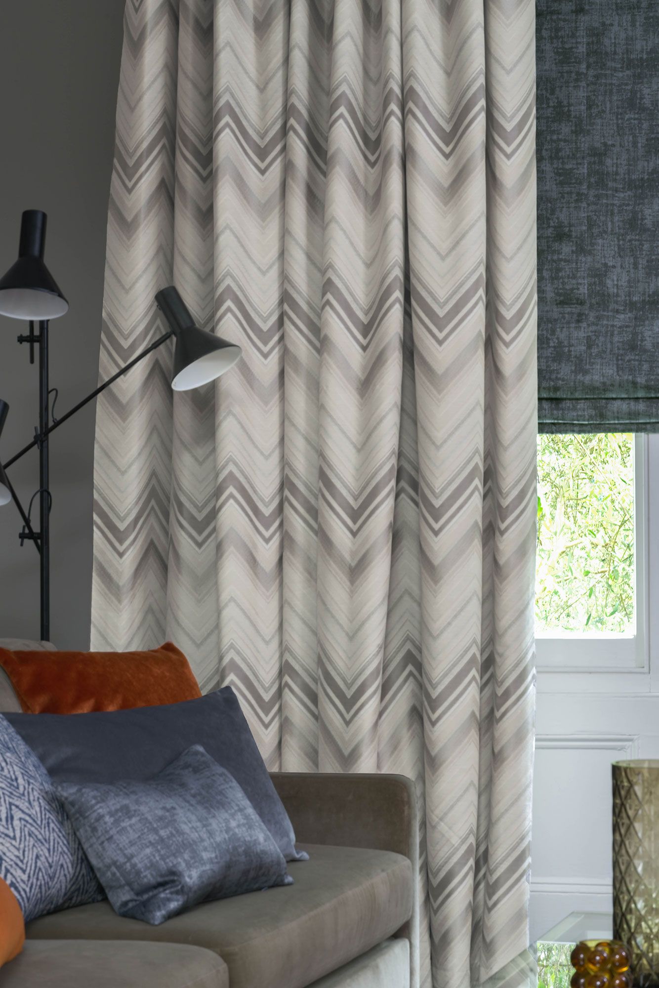Close up of Felix Pumice curtains and Dusk Charcoal romans in living room