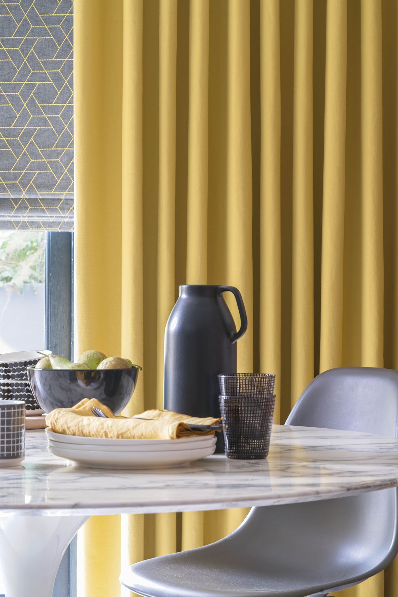 Close up of Mustard curtains and grey printed roman blinds in kitchen