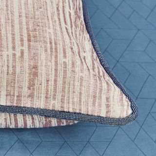 Beige and brown striped cushion with dark grey edge piping