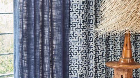 blue unlined curtain and white curtains featuring blue retro print hanging on doors in bedroom