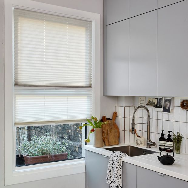 grenoble cream pleated blind in a white kitchen window with a spring tab fitted
