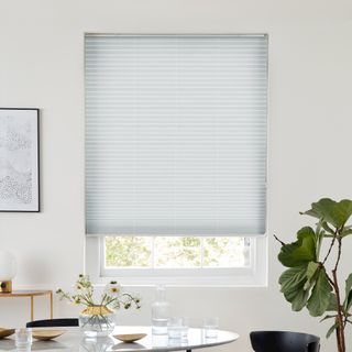 Silver pleated blind dressed on window