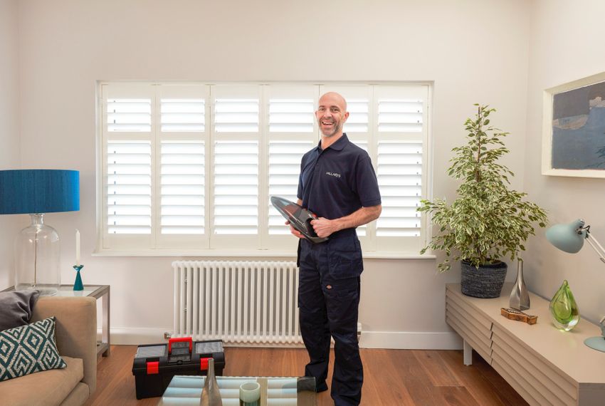 Advisor in front of white shutters and blue lamp