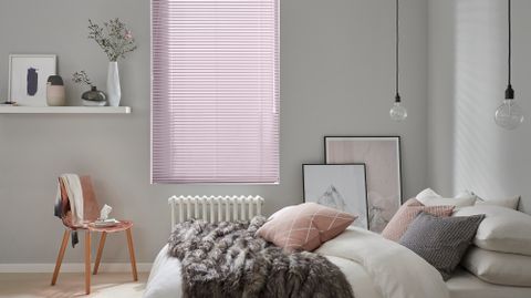 muted pink metal venetian blinds in a cosy, neutral bedroom