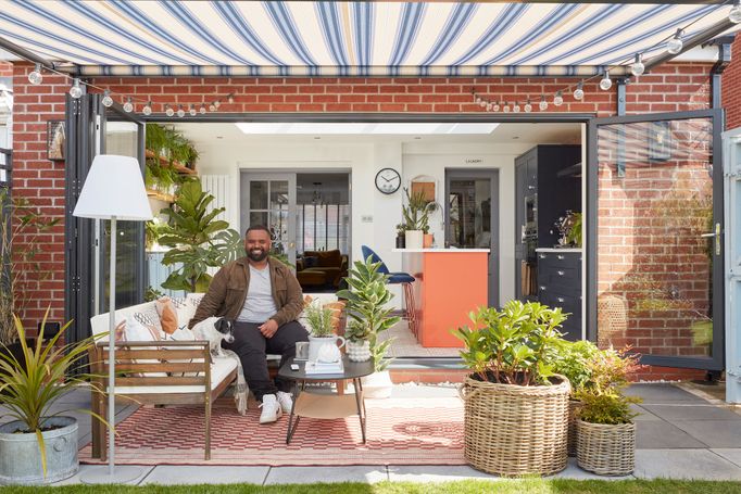 Mo sat on a bench under an awning in his garden 