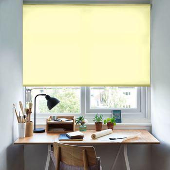 Reber Lemon Roller Blind with a desk in front of the window and a lamp on the table and office stationary
