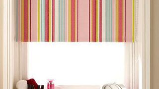 Striped pastel Circus Hot Pink roller blind hung in bedroom