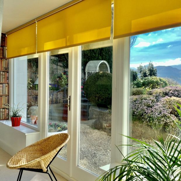 Acacia buttercup roller blinds on patio doors in living room