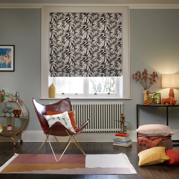 laurel eclipse white and black roman blind in homely room with chair, cushions and decoration