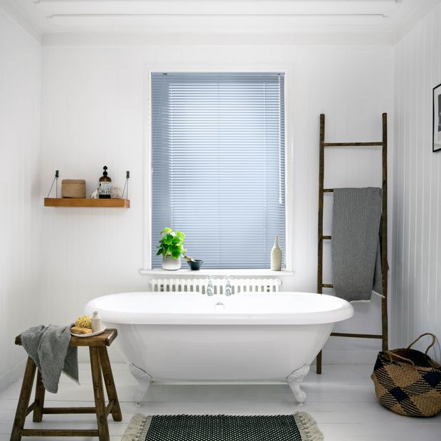 Sea blue metal venetian blinds in bathroom above bath