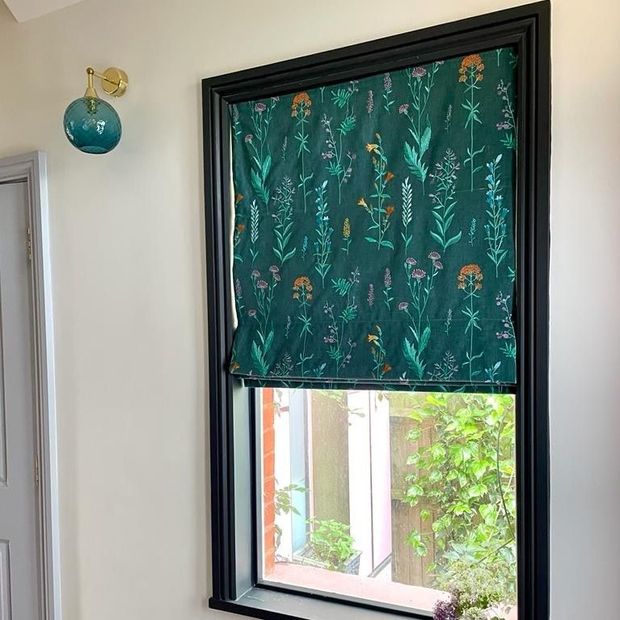 dark green floral roman blind on small window in hallway with pink doors