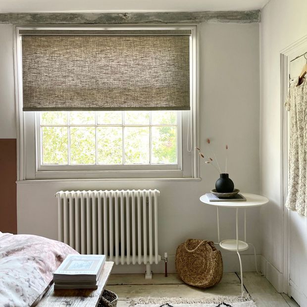 brown speckled roller blind on crittall window in cosy bedroom