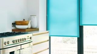 Plain blue Ravenna Aqua roller blind hung in kitchen
