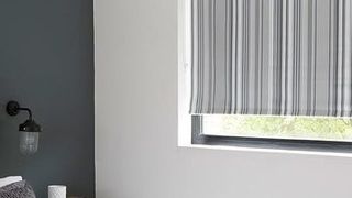 Roller blinds in Lester Silver hung in stylish grey bedroom