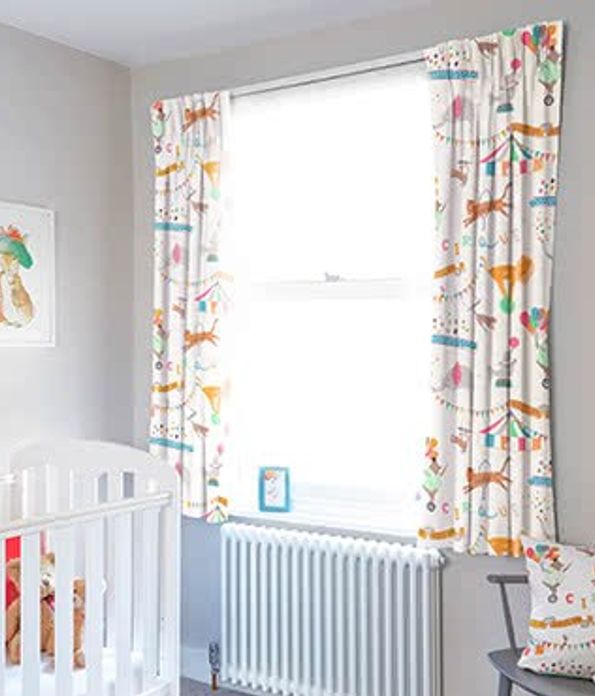 Children's room with cot and Circus Act curtains with matching pillow