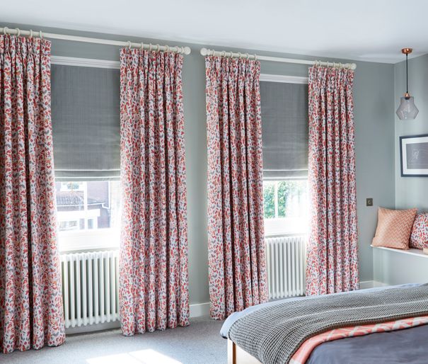 Bedroom with two windows dressed with Blossom Persimmon Pinch Pleat Curtains and Clarence Platinum Roman Blinds