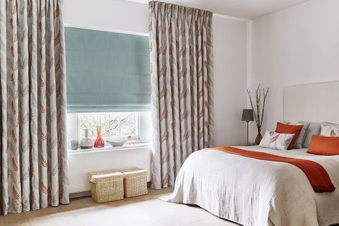 Neutral Bedroom with floral bedroom curtains in an orange and blue pattern