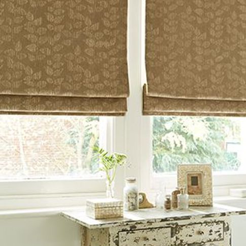 patterned light brown roman blinds in a window 