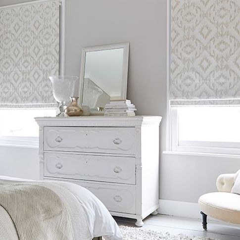 cream roman blinds in a bedroom with 2 windows 