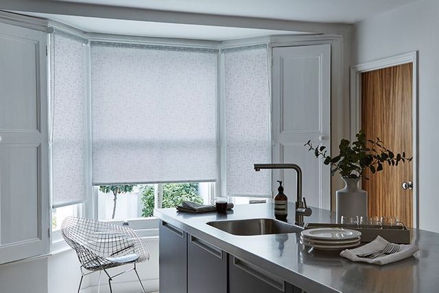 grey roller blinds in a kitchen window 