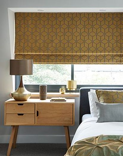 mustard yellow geometric patterned roman blind in a bedroom window