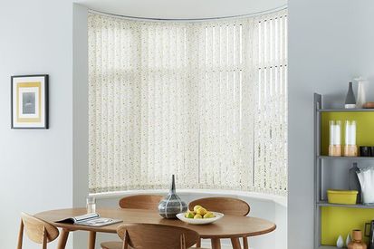 dining room with a bay window dressed with white vertical blinds