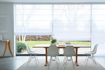 White Voile Roman blinds in large glass dining room expanse looking out to garden